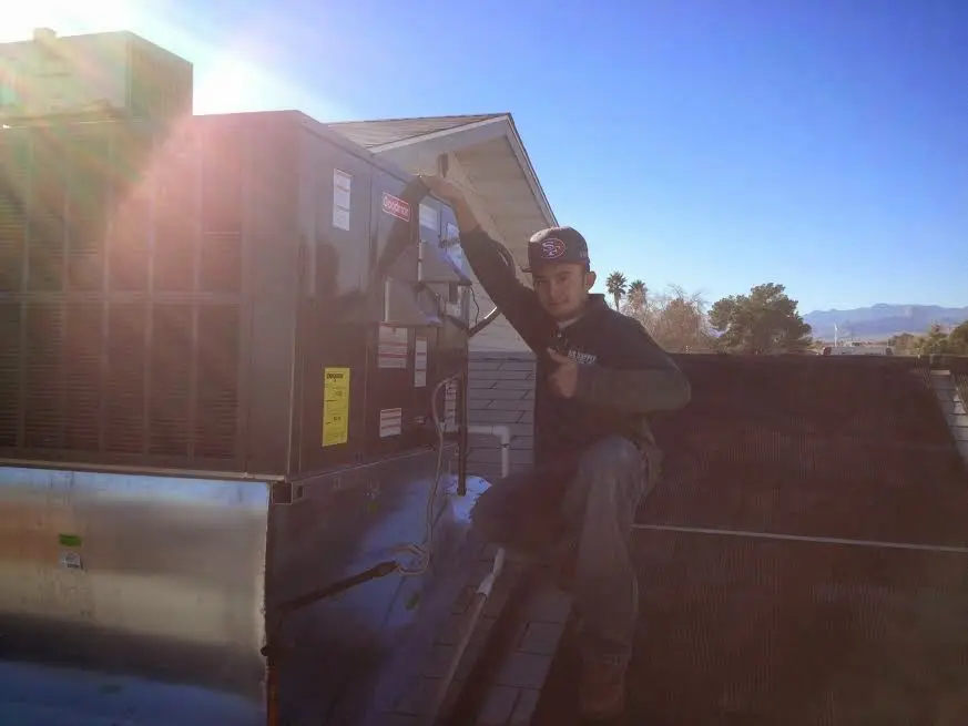 HVAC technician performing AC Tune-Up on a rooftop unit in Montrose-Ghent