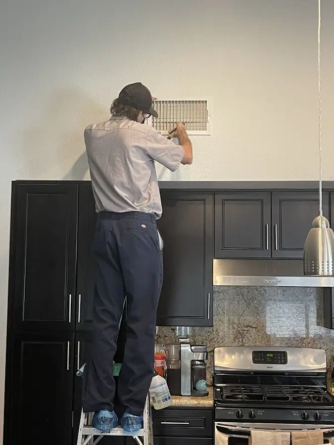 Technician inspecting an air vent during HVAC service in Montrose-Ghent